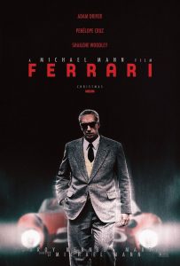 Affiche du film Ferrari.
Le fond est très sombre, presque noir. En haut, trois noms sont indiqués en rouge, les uns sur les autres: Adam Driver, Penelope Cruz, Shailene Woodley.Juste en dessous, un texte en blanc indique  "a Michael Mann film" (un film de Michael Mann)
Arrive ensuite le gros titre en rouge : "Ferrari".
Un seul acteur est sur l'affiche: Adam Driver, en plan italien, marche  en direction de l'objectif. Il est grimmé de sorte à avoir l'air plus vieux, porte un costard gris et des lunettes de soleil. Sa main droite est enfoncée dans sa poche, et il a un anneau sur l'annuaire gauche. Derrière lui, une voiture floutée aux phares allumés.
Par dessus ses jambes, un texte en blanc donne le nom du scénariste : Troy Kennedy Martin, puis redonne le nom du réalisateur.